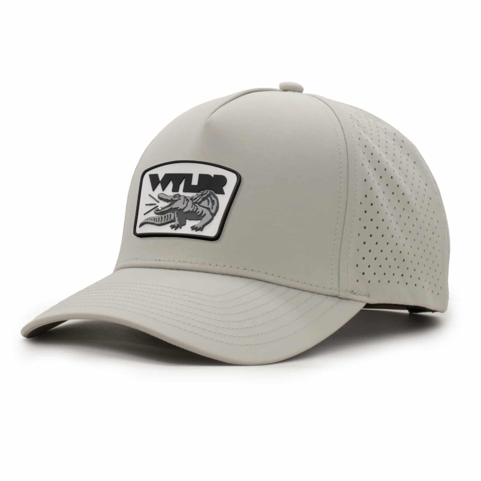 three-quarter view of a 5 panel, water resistant, floatable hat with a PVC patch. the patch is a gator catching a golf ball in its mouth and features the brand name, Wyldr. the hat is light tan